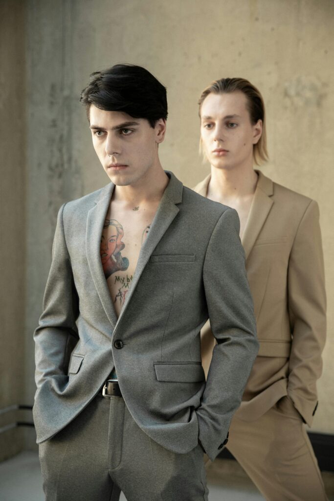 Chic studio portrait of two men in modern suits exuding elegance.