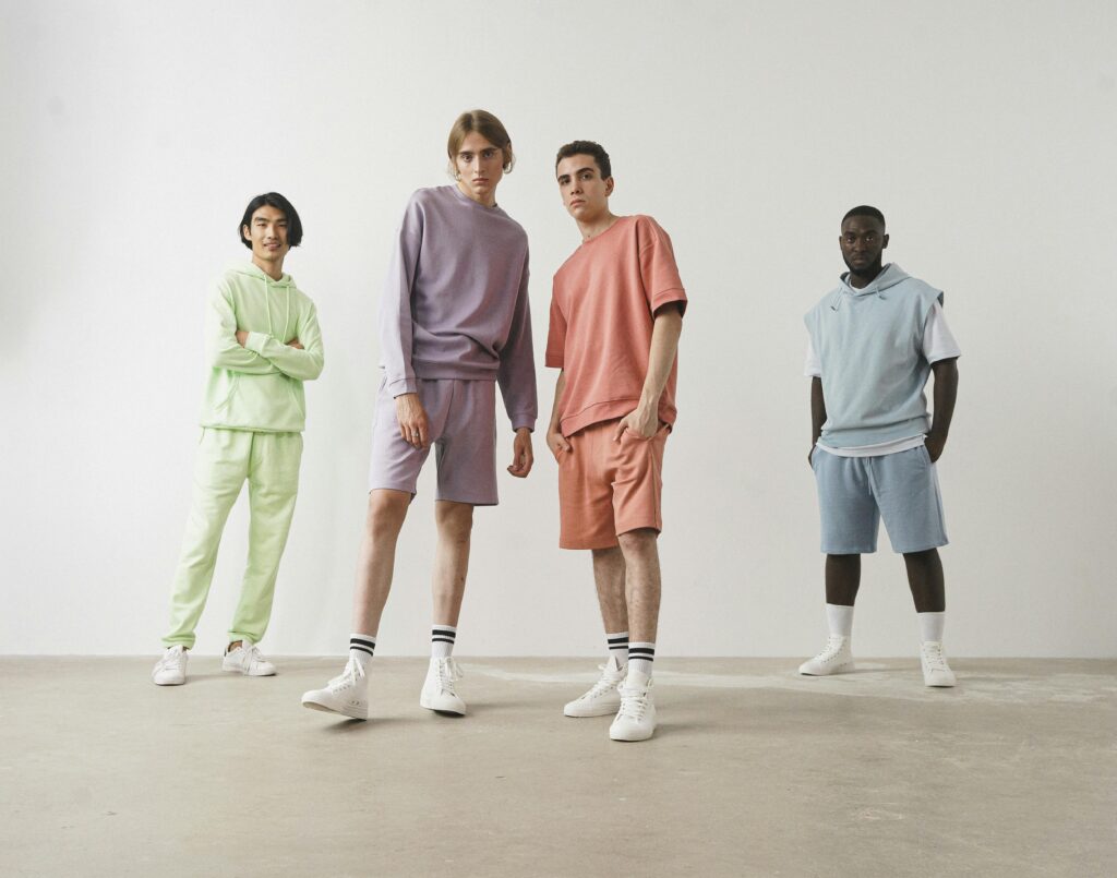 Stylish group of young models showcasing pastel casual wear in a minimalist setting.